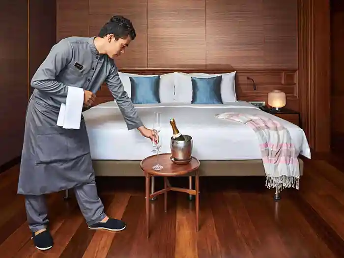 Aqua Mekong steward serving wine in stateroom.