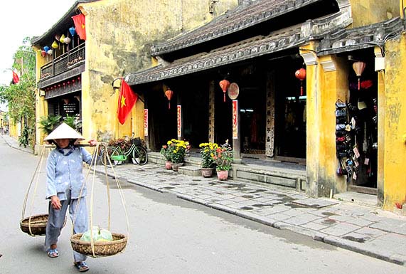 Old woman walking in Hoi An, Vietnam, by Patrick Morris