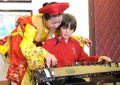 Child playing the dan bau in Hanoi
